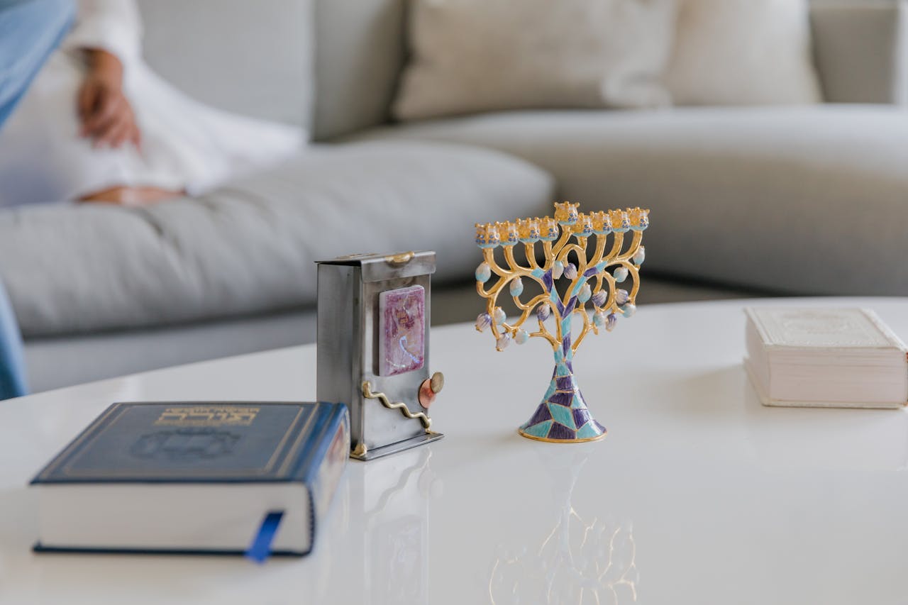 Close-up of Jewish religious items on a table setting, including a menorah and prayer books.